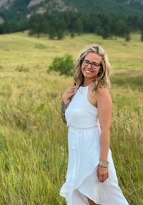 Colorado Springs Massage Therapist by popular Colorado Springs Massage Therapist, Camino Massage: image of a woman standing in a field and wearing a white halter dress. 