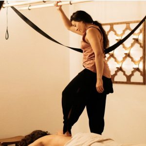 Colorado Springs Massage Therapist by popular Colorado massage blog, Camino Massage: image of a woman standing on another person's back as they lay facedown on a massage table. 